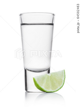 Glass shot of silver tequila with lime slice on Glass shot of silver tequila with lime slice on 64502463