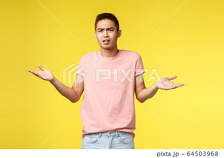 Whats your problem man. Portrait of displeased, frustarted young asian guy look bothered and confused, shrugging, spread hands sideways, cant understand what happened, stand yellow background 64503968