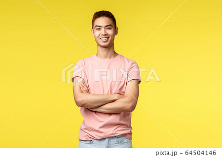 Vacation, summer and people concept. Happy good-looking young hipster guy enjoying leisure, cross arms chest, proudly smiling and looking camera satisfied, standing yellow background Vacation, summer and people concept. Happy good-looking young hipster guy enjoying leisure, cross arms chest, proudly smiling and looking camera satisfied, standing yellow background 64504146