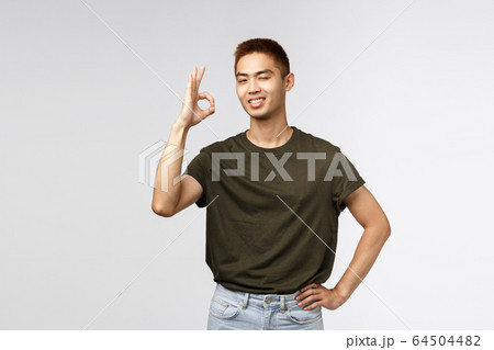 No problem, leave it to me. Satisfied and confident, assertive young asian man standing relaxed and carefree, wink encourage friend, show okay sign guarantee best quality, recommend service No problem, leave it to me. Satisfied and confident, assertive young asian man standing relaxed and carefree, wink encourage friend, show okay sign guarantee best quality, recommend service 64504482