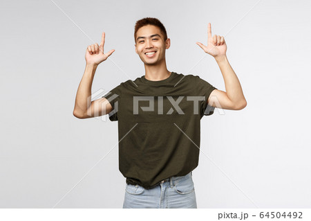 Portrait of proud happy, smiling asian young man, teen guy pointing fingers up and grinning at camera satisfied, person showing way to promo, advertise product or company banner Portrait of proud happy, smiling asian young man, teen guy pointing fingers up and grinning at camera satisfied, person showing way to promo, advertise product or company banner 64504492