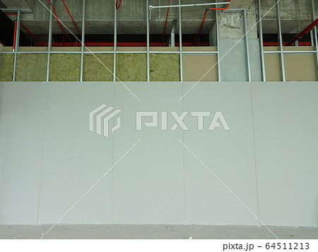 Drywall installation work in progress by construction workers at the construction site. It is the easiest and cheapest way to do partition for an interior wall.  64511213