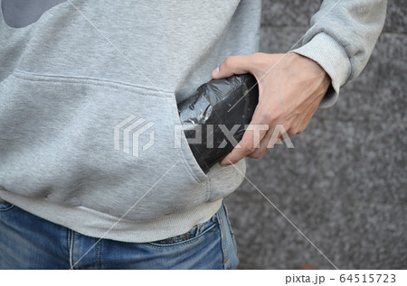Drug dealer taking bag with cocaine out of hoodie 64515723