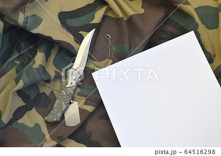 Blank paper with knife and army dog tag lies on Blank paper with knife and army dog tag lies on 64516298