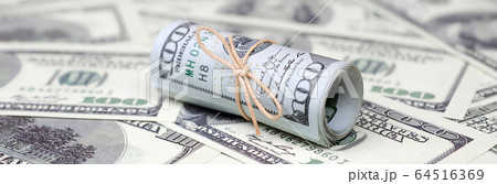 US dollars rolled up and tightened with band lies US dollars rolled up and tightened with band lies 64516369