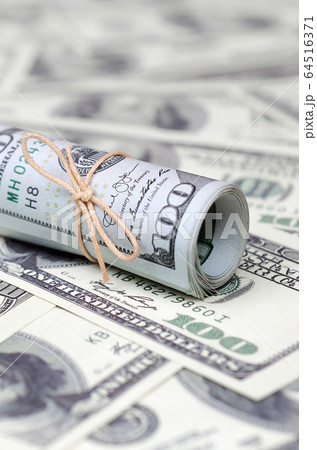 US dollars rolled up and tightened with band lies 64516371