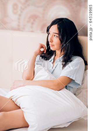 Beautiful woman sitting in bed in morning 64519965
