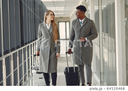 Elegant black man at the airport with his businesspartner 64520468