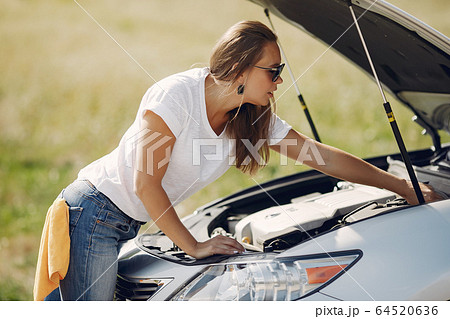 Elegant woman wipes the car with a rag Elegant woman wipes the car with a rag 64520636