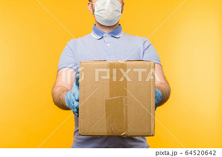 Man holding cardboard boxes in medical rubber Man holding cardboard boxes in medical rubber 64520642