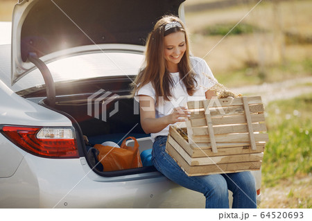 Elegant woman sitting in a trunk with wood box Elegant woman sitting in a trunk with wood box 64520693
