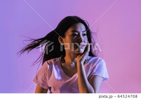 Beautiful asian woman in neon, wind develops hair 64524708