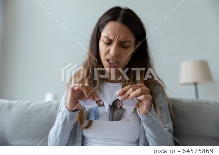 Unhappy angry woman tearing picture, divorce and relationship problem Unhappy angry woman tearing picture, divorce and relationship problem 64525869