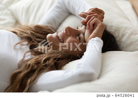 Close up happy beautiful woman lying in bed, enjoying morning Close up happy beautiful woman lying in bed, enjoying morning 64526041