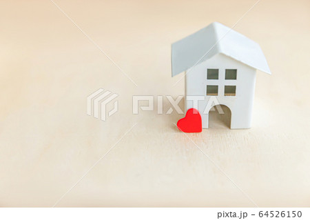 Miniature toy model house with red heart on wooden 64526150