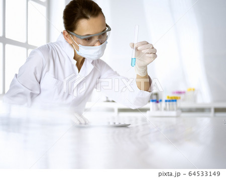 Female laboratory assistant analyzing test tube with blue liquid. Medicine, health care and researching concept 64533149