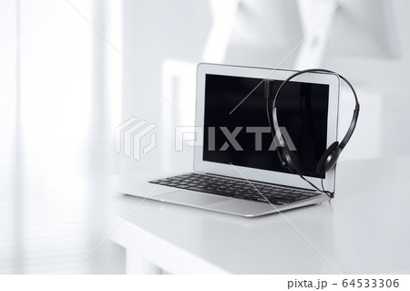 Call center and communication support, customer service help desk. VOIP headset on laptop computer Call center and communication support, customer service help desk. VOIP headset on laptop computer 64533306