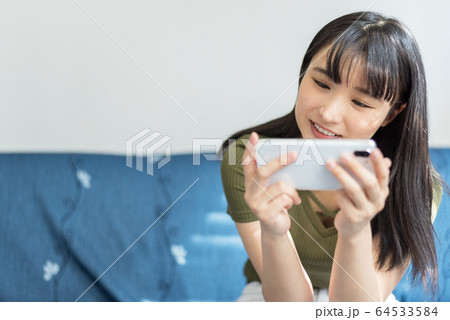 スマホでゲームまたは動画を楽しむ学生 スマホでゲームまたは動画を楽しむ学生 64533584