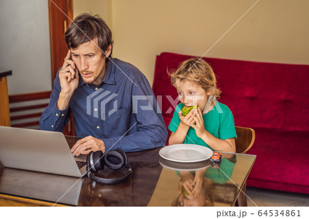 Man is trying to work from home because of the coronovirus epidemic, but his son is stopping him Man is trying to work from home because of the coronovirus epidemic, but his son is stopping him 64534861