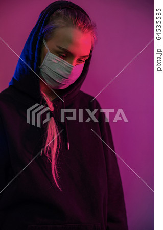 Exhausted or depressed woman in protective face mask with multi colored lights 64535535