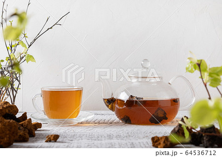Chaga mushrooms infusion in glass cup. 64536712