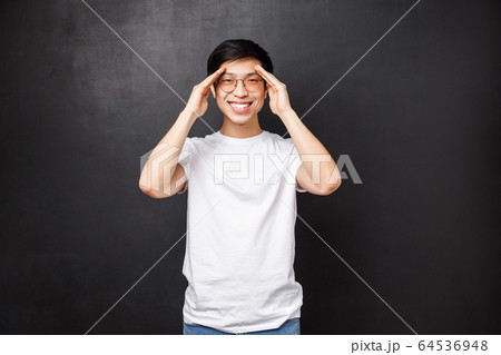 Happy charismatic young man feel well, got better after having prescribed medicine, smiling camera and hold hands near forehead as if seeing something distance, found perfect spot Happy charismatic young man feel well, got better after having prescribed medicine, smiling camera and hold hands near forehead as if seeing something distance, found perfect spot 64536948
