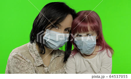Sick mother hug daughter in medical mask. Coronavirus concept. Family quarantine Sick mother hug daughter in medical mask. Coronavirus concept. Family quarantine 64537055