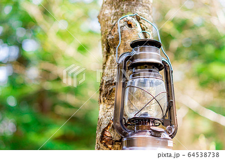 キャンプ素材　木に掛かったオイルランタン 64538738