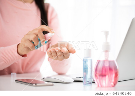 Closeup woman hands using alcohol spray to her Closeup woman hands using alcohol spray to her 64540240