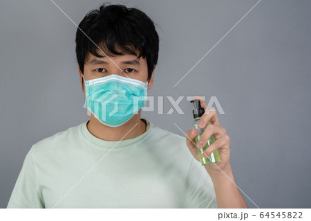 man in medical mask(surgical mask) using alcohol man in medical mask(surgical mask) using alcohol 64545822