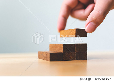 Hand arranging wood block stacking as step stair Hand arranging wood block stacking as step stair 64548357
