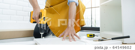 close up man holding cordless screwdriver machine 64549602