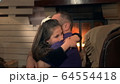 Happy father and small daughter embracing each other on armchair near the fireplace 64554418