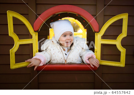Funny portrait of baby girl looking through toy 64557642