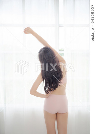 Beautiful young asian woman waking up in the morning stand stretching arms in the bedroom Beautiful young asian woman waking up in the morning stand stretching arms in the bedroom 64559957