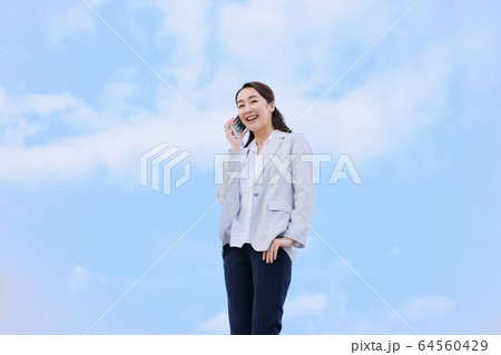 女性 青空 スマホ 女性 青空 スマホ 64560429