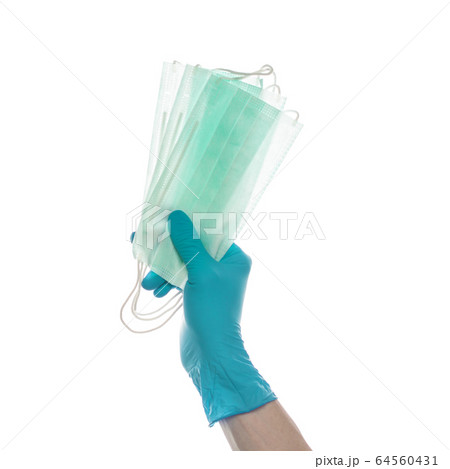 Hand in blue doctor gloves giving Medical mask 64560431