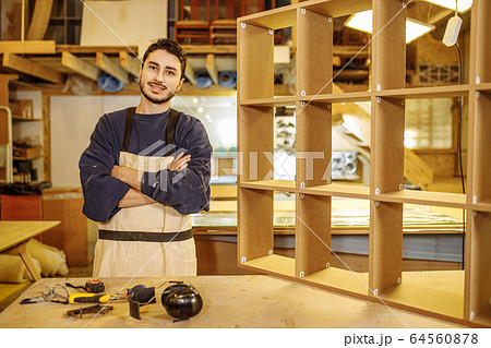 portrait of positive smiling carpenter at work place portrait of positive smiling carpenter at work place 64560878