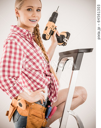 Girl using some power tools for work at home 64561303