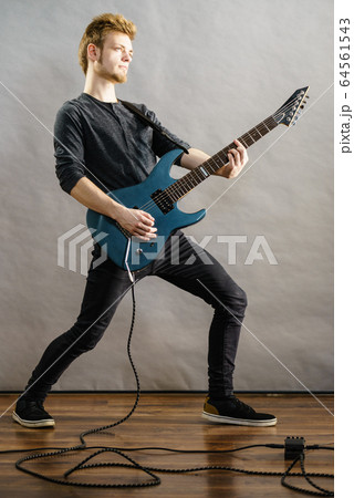 Young man playing electric guitar 64561543