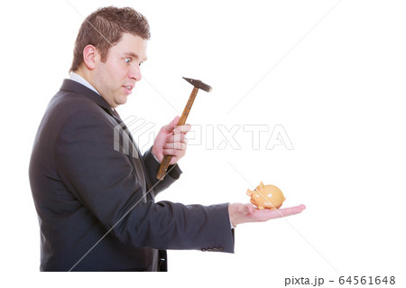 Man trying to break piggy bank with hammer 64561648