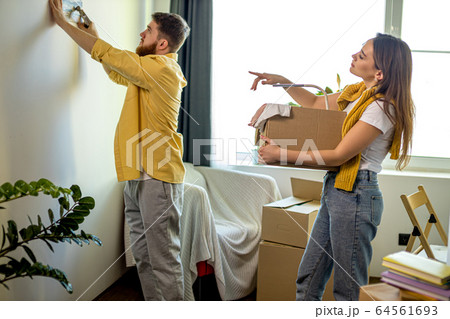 young caucasian married couple unpacking boxes at home 64561693