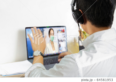 Man having video call with wife in protective medical mask at home. Man having video call with wife in protective medical mask at home. 64561953