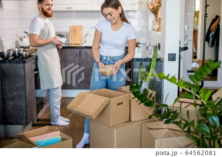 beautiful caucasian married couple unpacking boxes at home beautiful caucasian married couple unpacking boxes at home 64562081