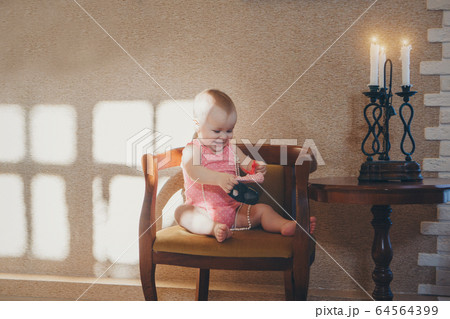 a child plays with shoes. a girl becomes a little lady. Concept of fine motor skills development, educational games, childhood, children's day, kindergarten. Ads for shoes and fashion. copy space a child plays with shoes. a girl becomes a little lady. Concept of fine motor skills development, educational games, childhood, children's day, kindergarten. Ads for shoes and fashion. copy space 64564399
