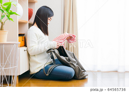 洋服をリュックに入れる女性 コピースペース 洋服をリュックに入れる女性 コピースペース 64565736