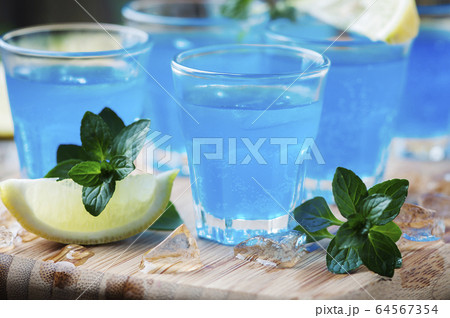 Blue curacao liqueur with lemon on the wooden 64567354