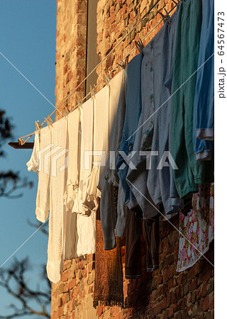Clothes hanging out to dry on a clothesline in Tuscany Italy Clothes hanging out to dry on a clothesline in Tuscany Italy 64567473