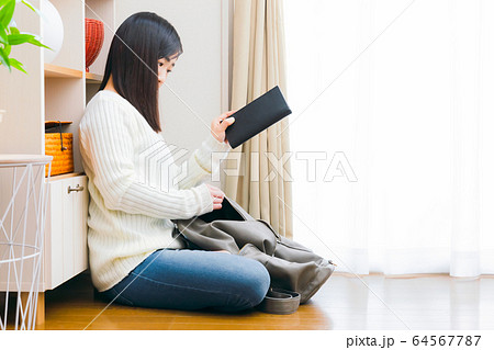 財布をリュックに入れる女性　コピースペース 64567787