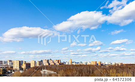 blue sky with clouds over city street and park 64572306